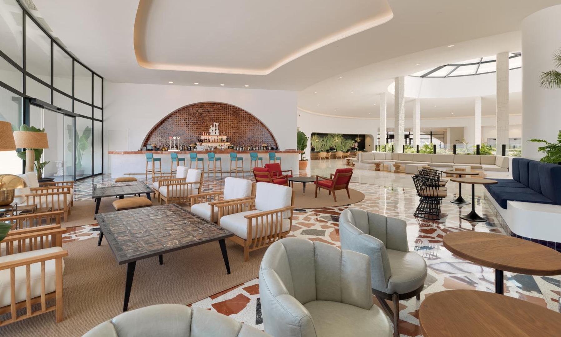 Viesnīcas H10 Atlantic Sunset plašais lobby bārs un atpūtas zona ar dizaina mēbelēm — gaišs interjers un panorāmas logi