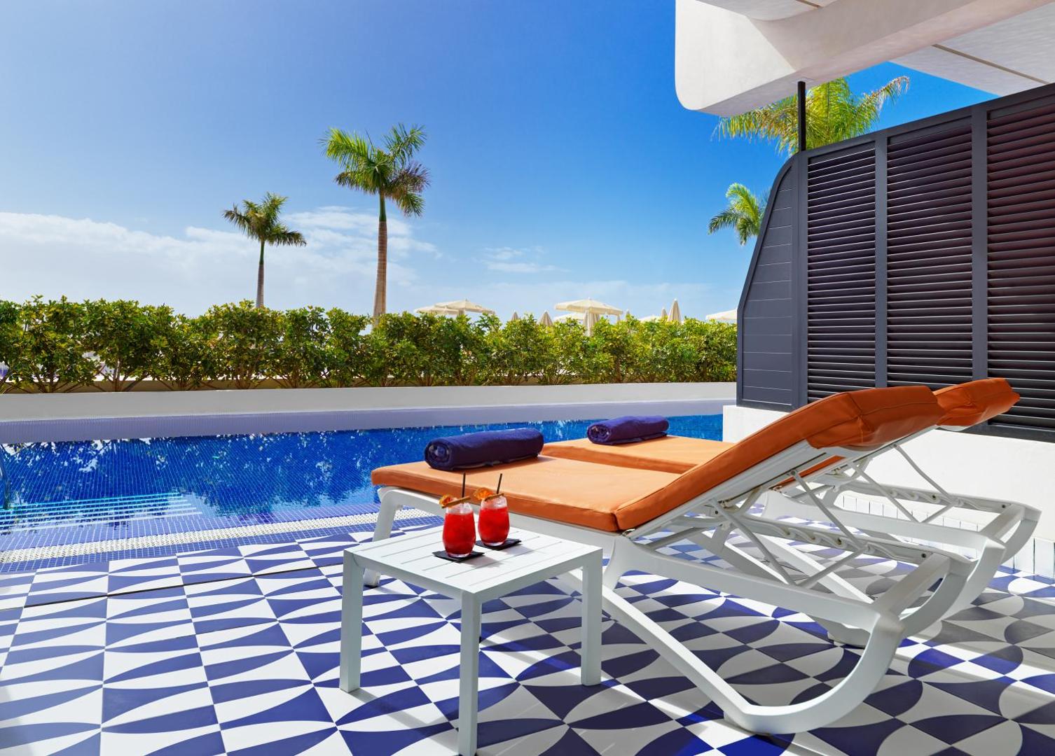 H10 Atlantic Sunset Horizons Collection numurs ar tiešu piekļuvi baseinam Tenerifē — terase ar sauļošanās krēsliem un kokteiļiem pie ūdens