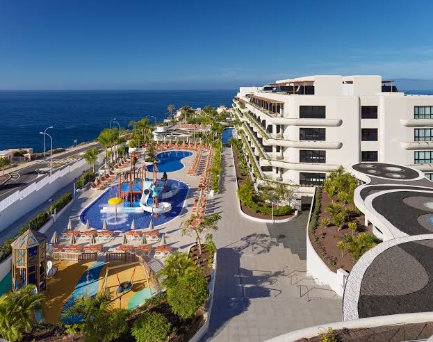 H10 Atlantic Sunset viesnīcas skats no augšas uz bērnu baseinu ar slidkalniņiem un rotaļu laukumu Tenerifes piekrastē