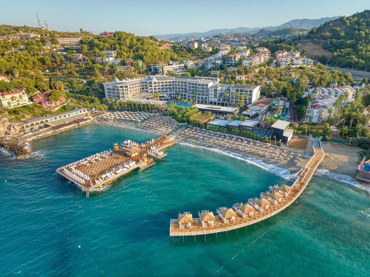 Seven Seas Palmeras Bay viesnīcas panorāmas skats Alanjā ar privāto pludmali, diviem koka moliem un galveno ēku piekrastē