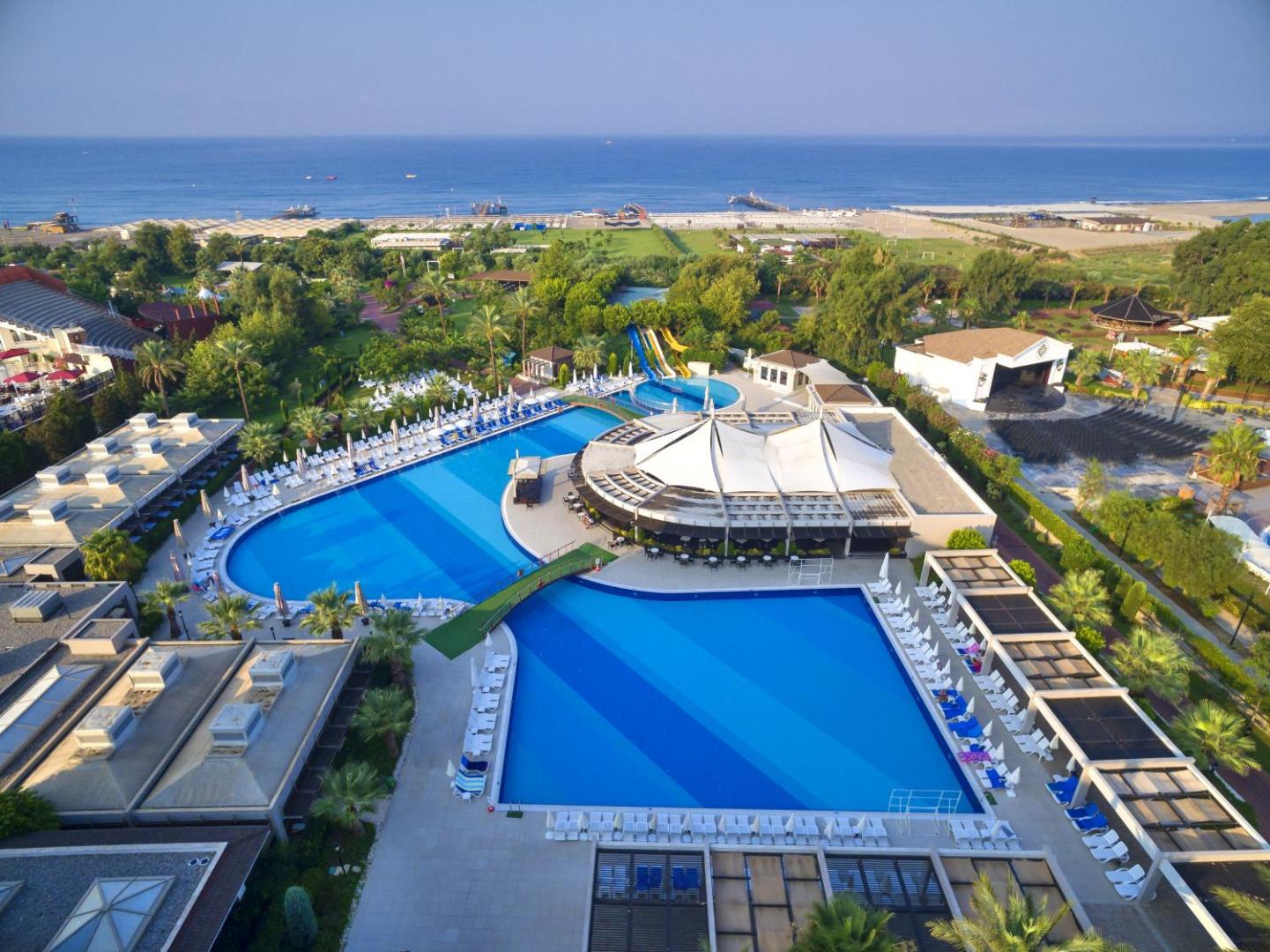 Sunis Elita Beach Resort Hotel & SPA panorāmas skats uz baseinu kompleksu, dārzu un Vidusjūras piekrasti Sides reģionā, Turcijā