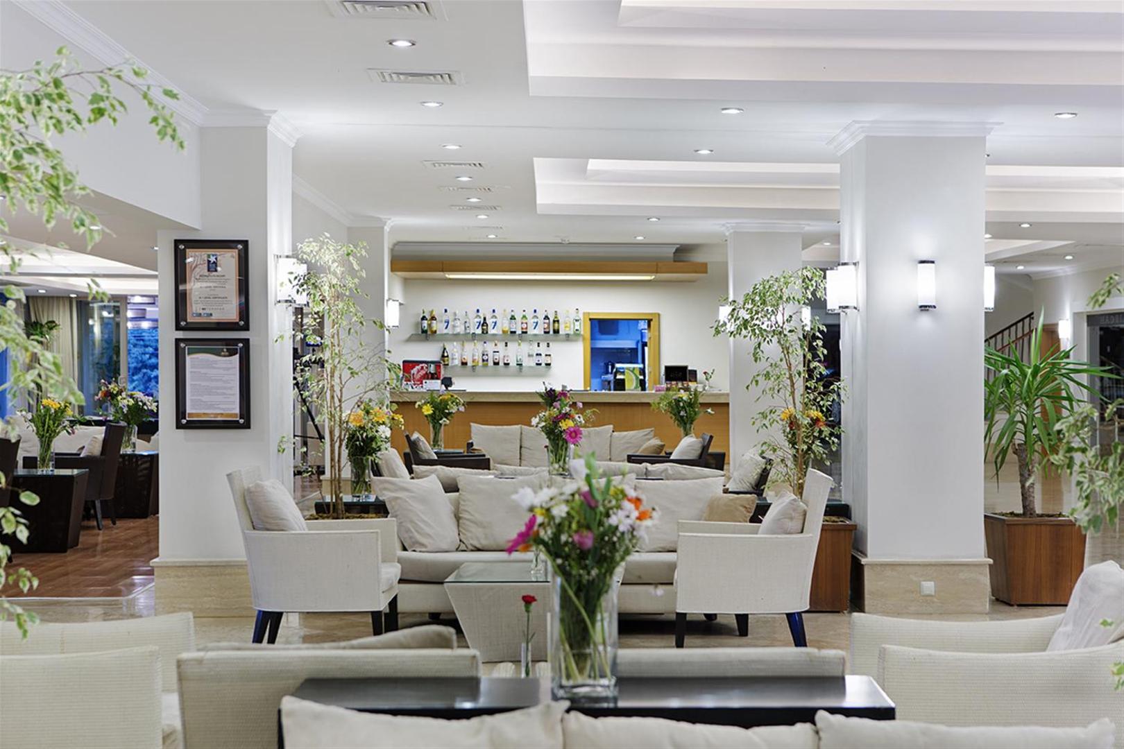 Sunis Elita Beach Resort lobby bāra zona ar mīkstiem dīvāniem, dekoratīviem augiem un plašu dzērienu izvēli fonā.