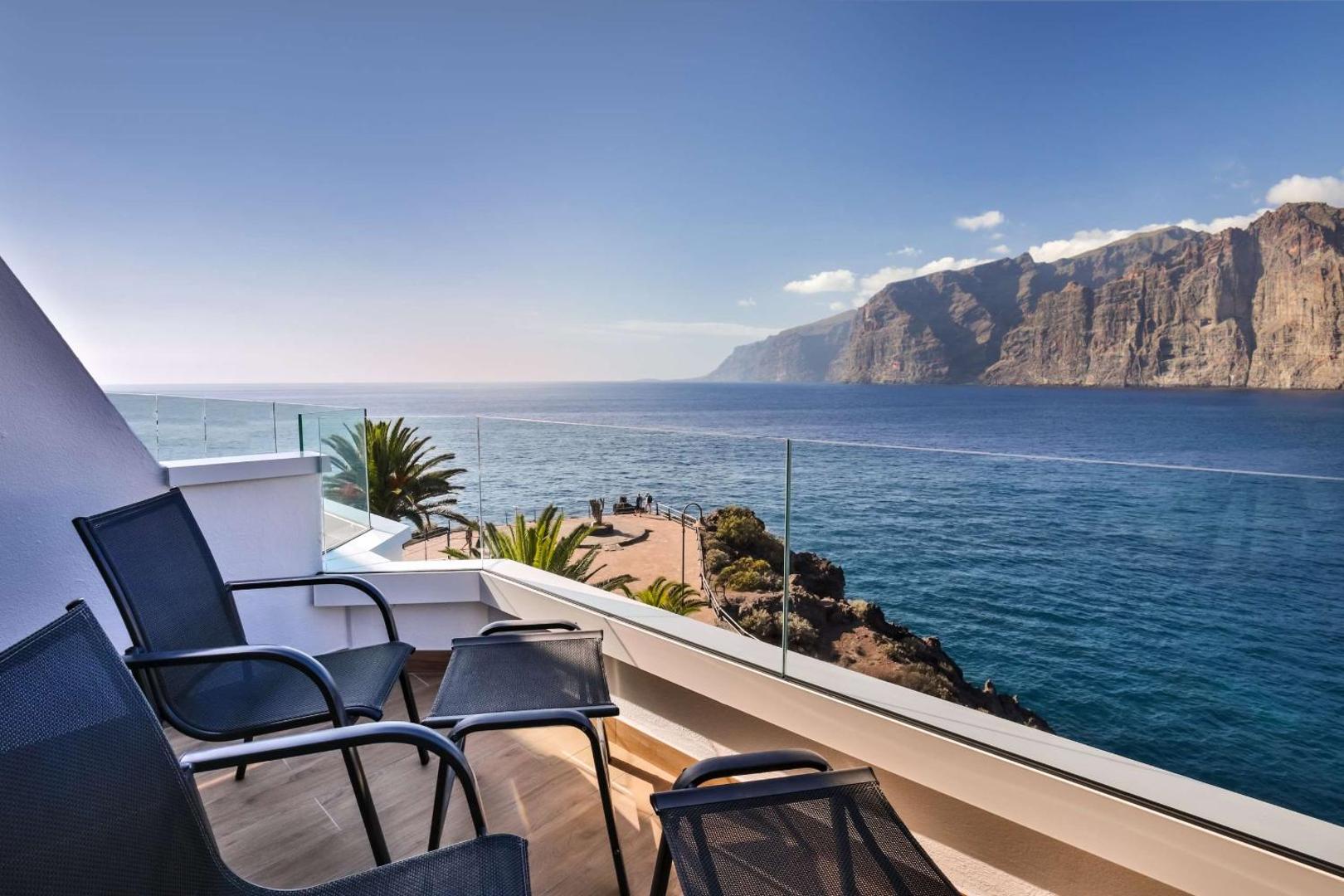Skats no Barceló Santiago balkona uz Atlantijas okeānu un Los Gigantes klintīm Tenerifē, mēbelēts balkons ar krēsliem.
