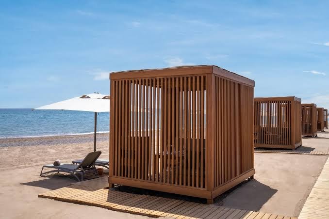 Lusso Sorgun privātā pludmale ar koka bungalo tipa nojumēm, sauļošanās krēsliem un saulessargiem Vidusjūras piekrastē, Turcijā