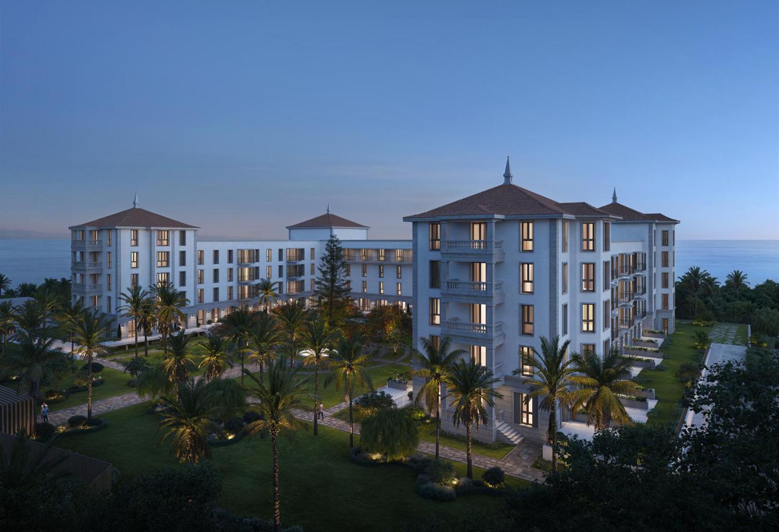 Gran Hotel Taoro viesnīcas fasāde vakarā ar izgaismotiem logiem un palmu dārzu Tenerifē — skats uz okeānu saulrieta stundā