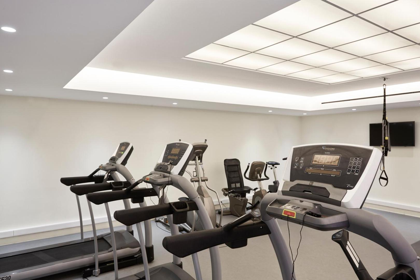 Sentido Apollo Palace moderns fitness centrs ar skrejceļiem un velotrenažieriem — gaiša un aprīkota sporta zāle aktīvai atpūtai Korfu salā