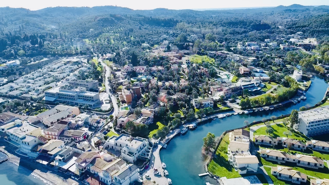 Sentido Apollo Palace un Mesongi ciemata panorāmas skats no putna lidojuma — upe, jūra un zaļie Korfu kalni