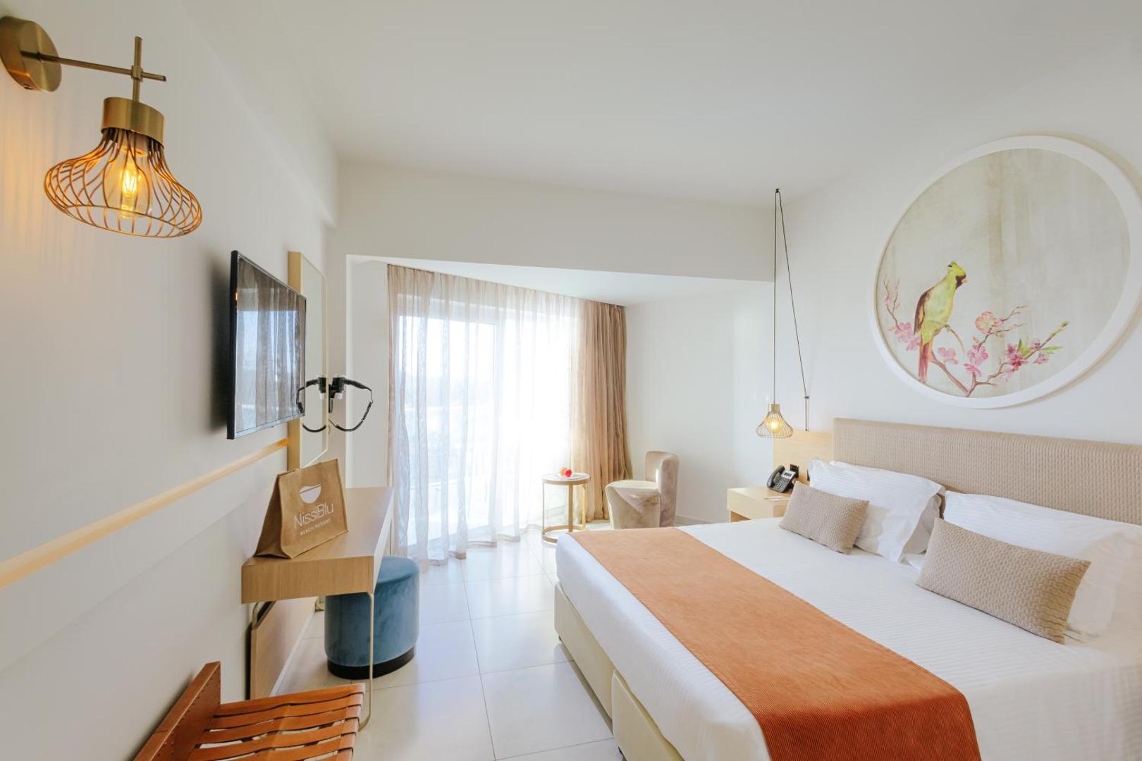 NissiBlu Beach Resort gaišs divvietīgs numurs Ajanapā, Kiprā — moderna guļamistaba ar balkonu, dizaina gaismekļiem un dekoratīvu sienas gleznojumu