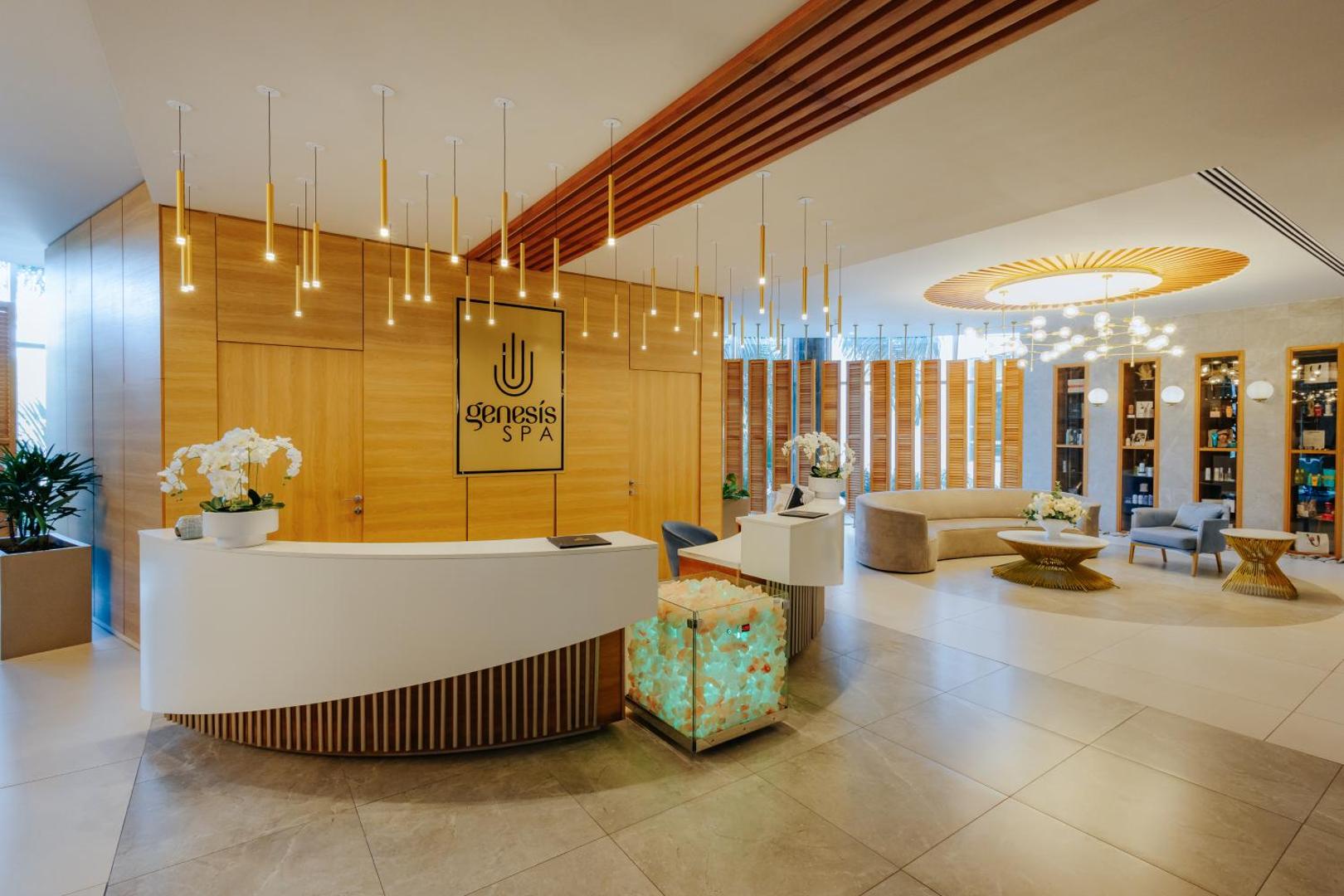 Nissiblu Beach Resort Genesis Spa centra reģistratūra ar modernu apgaismojumu, gaišām mēbelēm un relaksējošu interjeru