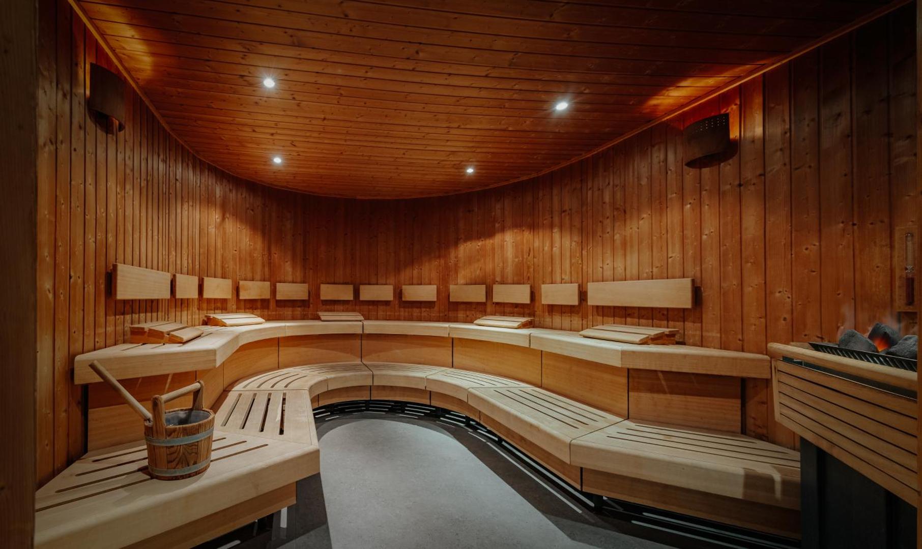 Nissiblu Beach Resort spa kompleksa lielā koka sauna ar ergonomiskiem soliem un siltu, mājīgu apgaismojumu