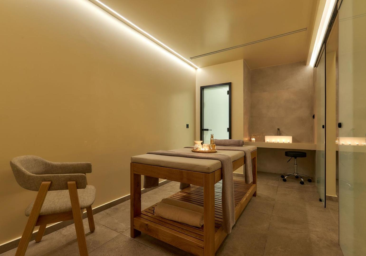 Procedūru numurs Enorme Santanna Island spa centrā ar masāžas galdu, koka mēbelēm un mierīgu apgaismojumu.