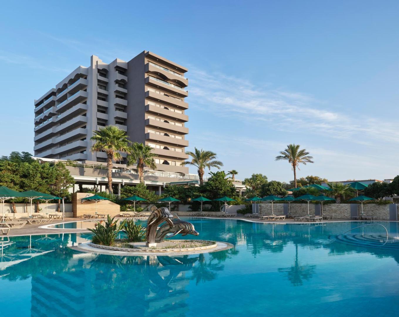 Esperos Mare Resort & Spa ēka ar lielu āra peldbaseinu un palmām priekšplānā.