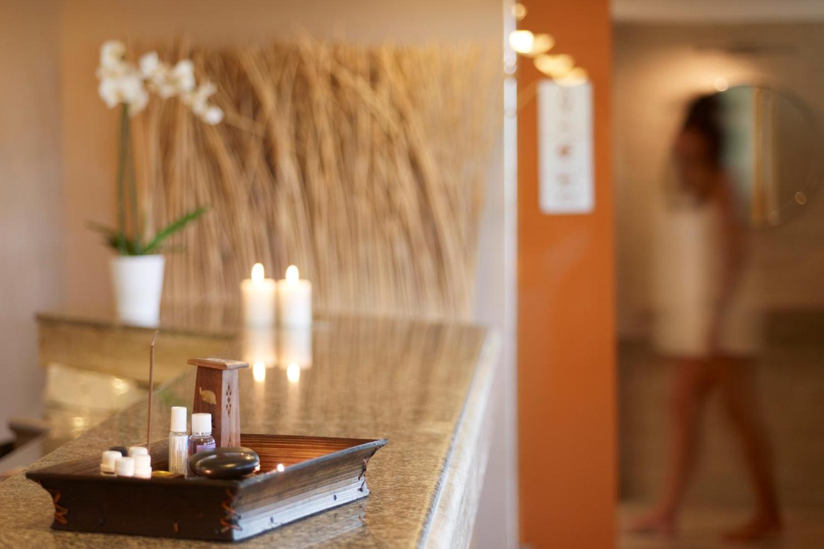 SPA centra recepcijas lete ar svecēm, aromātiskajām eļļām un dekoratīviem elementiem.