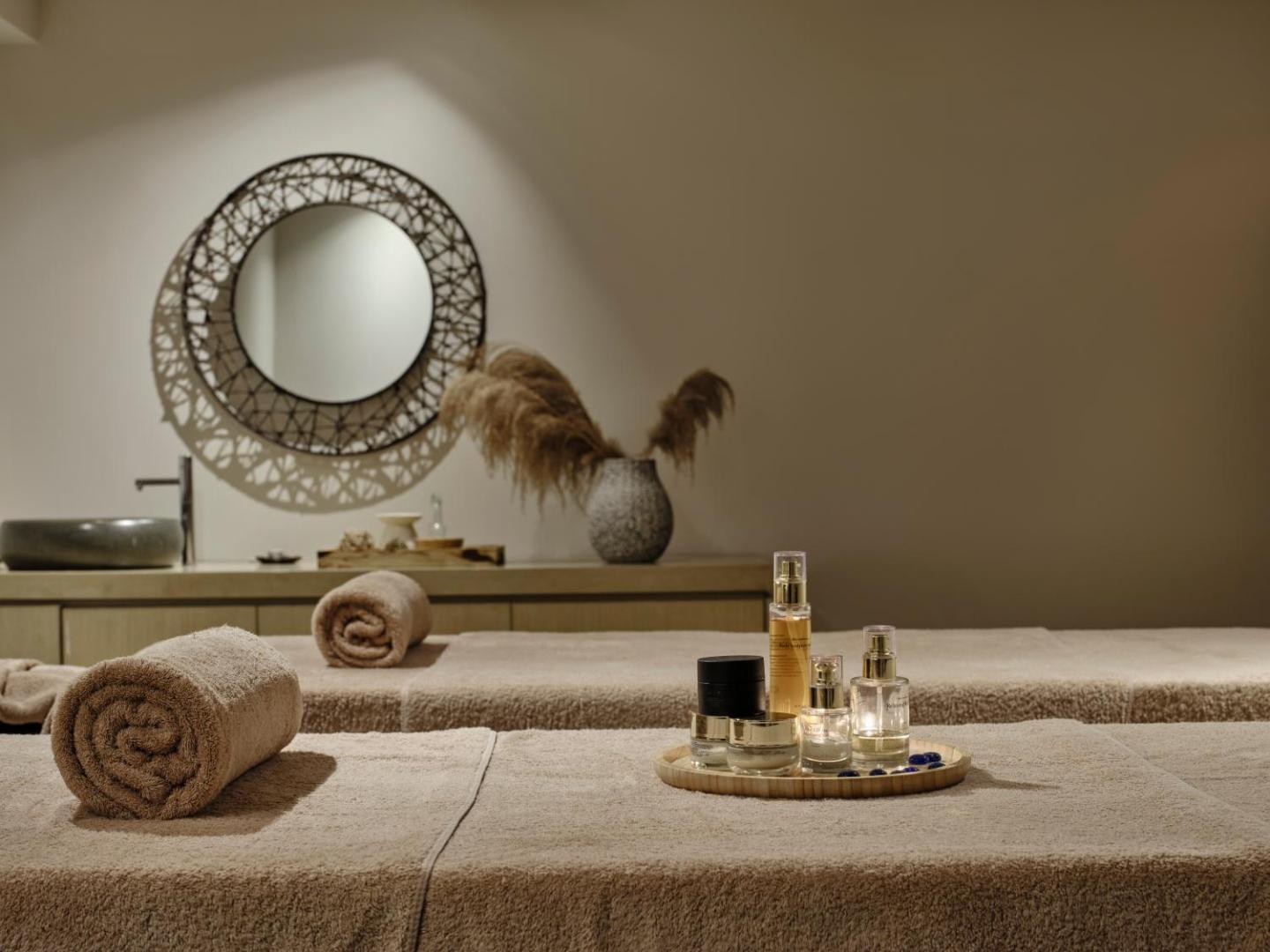 Atlantica Grand Mediterraneo Resort spa procedūru telpa ar masāžas galdiem, dvieļiem un aromātiskajām eļļām relaksācijai