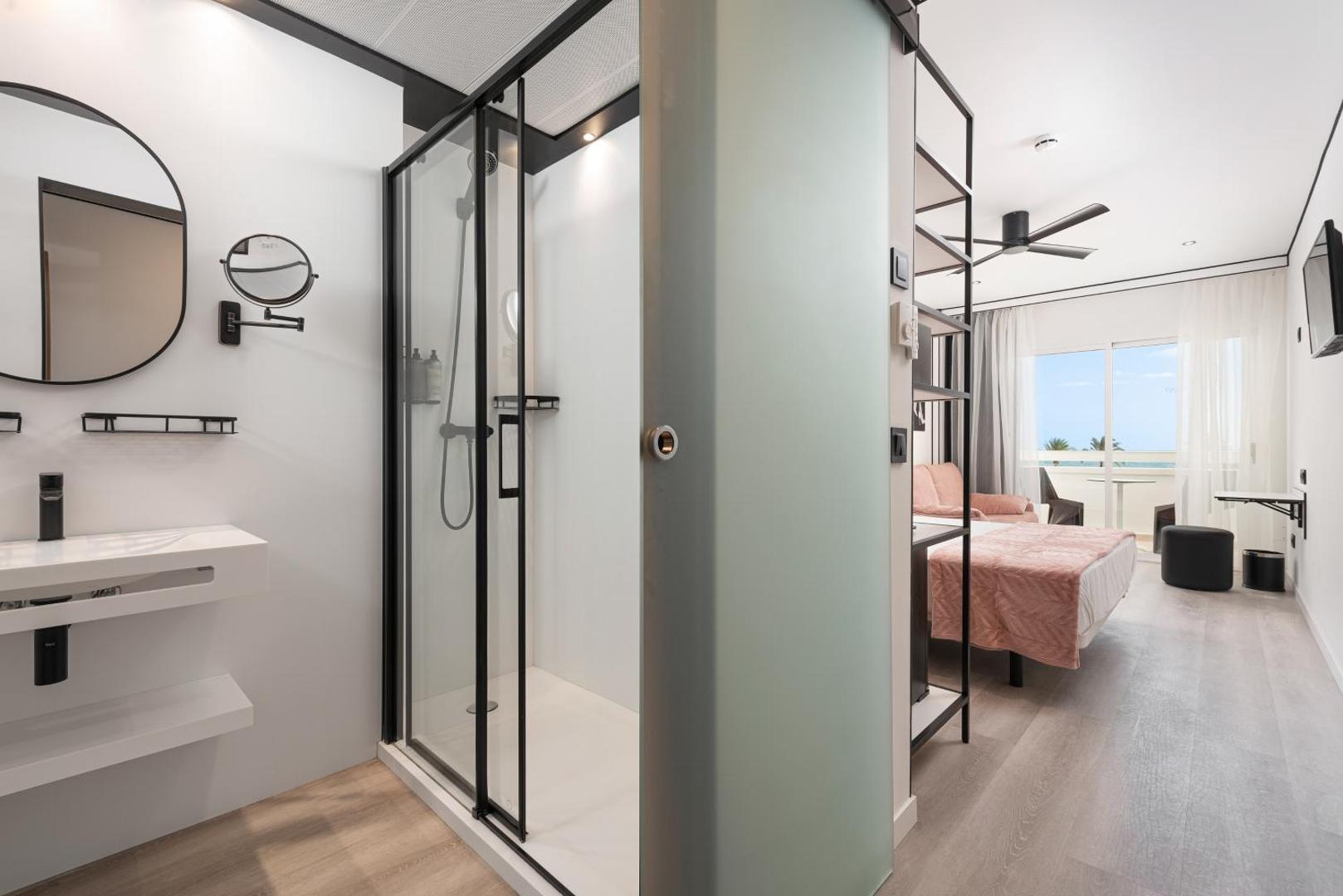 Hotel Condesa numura vannasistaba ar modernu dušas kabīni un skatu uz dzīvojamo zonu un balkonu