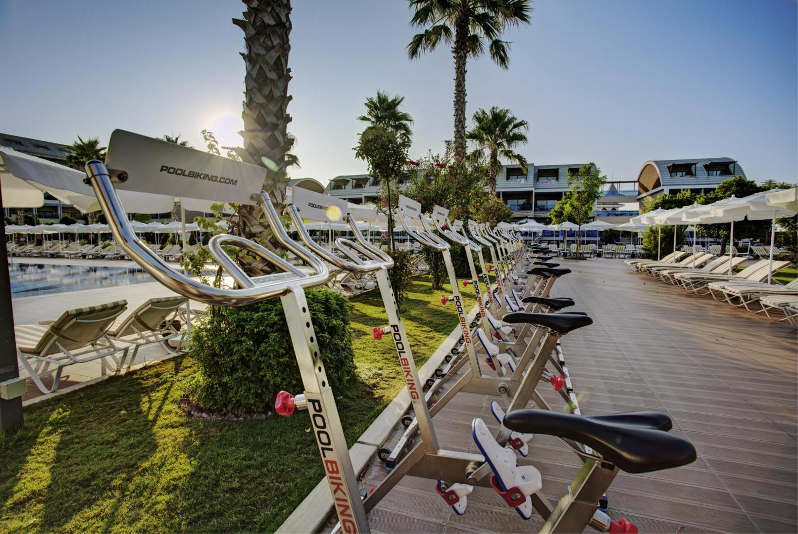 TUI Magic Life Jacaranda āra baseina zona ar Poolbiking ūdens velosipēdiem un saulessargiem piekrastes kūrortā Turcijā