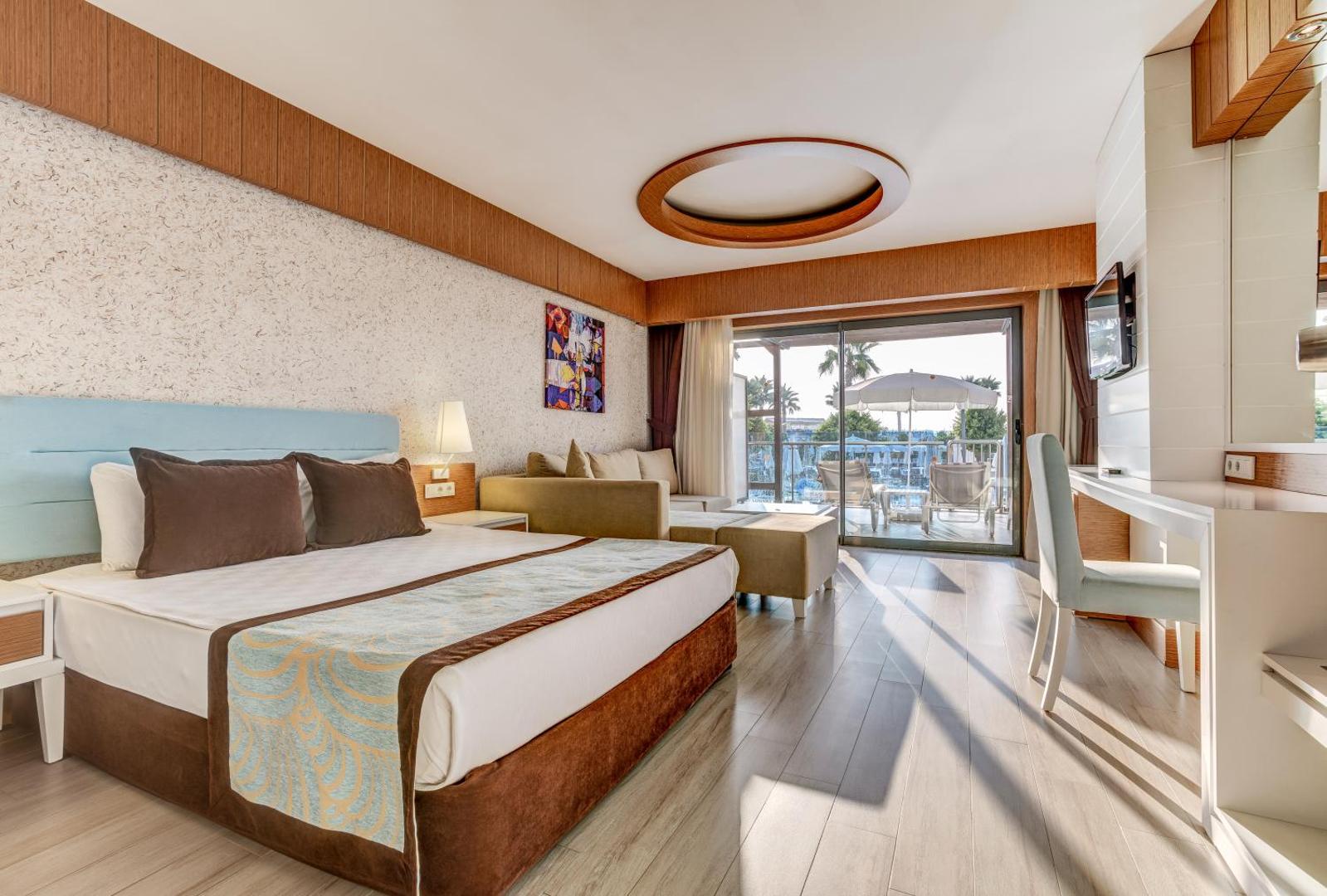 TUI Magic Life Jacaranda plašs viesnīcas numurs ar atpūtas zonu un skatu uz terasi — gaišas koka grīdas un moderns apgaismojums