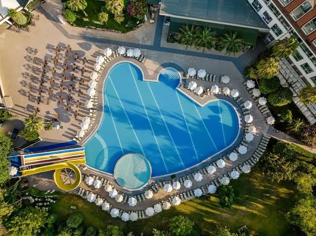 Greenwood Kemer Resort skats no putna lidojuma uz lielo āra baseinu ar saulessargiem un ūdens slidkalniņu Kemeras reģionā, Turcijā
