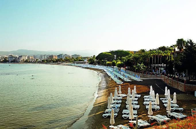 Lonicera Resort & Spa Hotel piekrastes līnija no putna lidojuma, parādot līci, pludmales zonu un apkārtējo pilsētas ainavu Alanjā