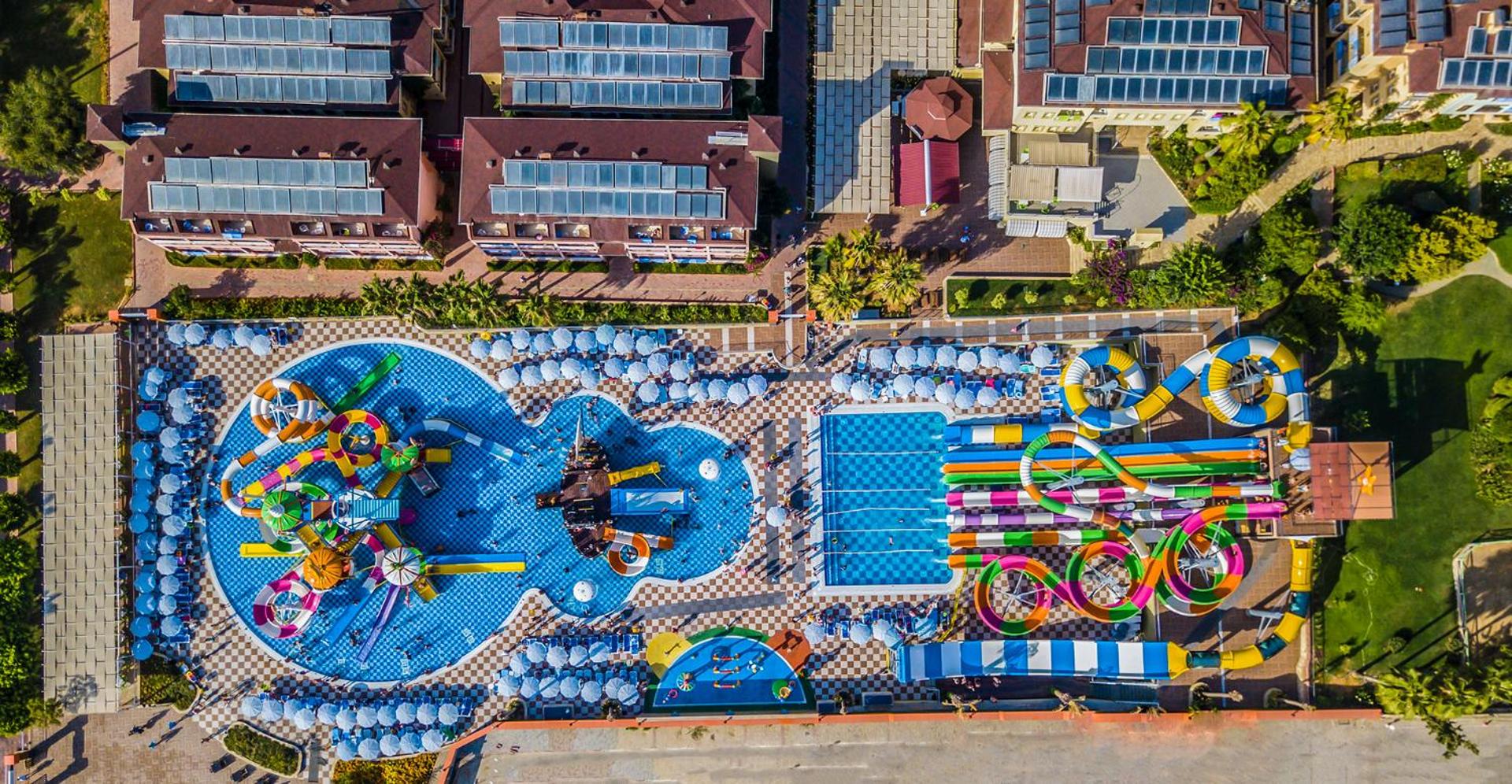 Lonicera Resort & Spa Hotel milzīgs akvaparks ar krāsainiem slidkalniņiem un vairākiem baseiniem skatā no putna lidojuma