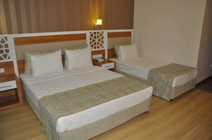 Lonicera Resort & Spa Hotel viesnīcas numurs ar divguļamo gultu un papildu gultu, dekorēts gaišos un brūnos toņos