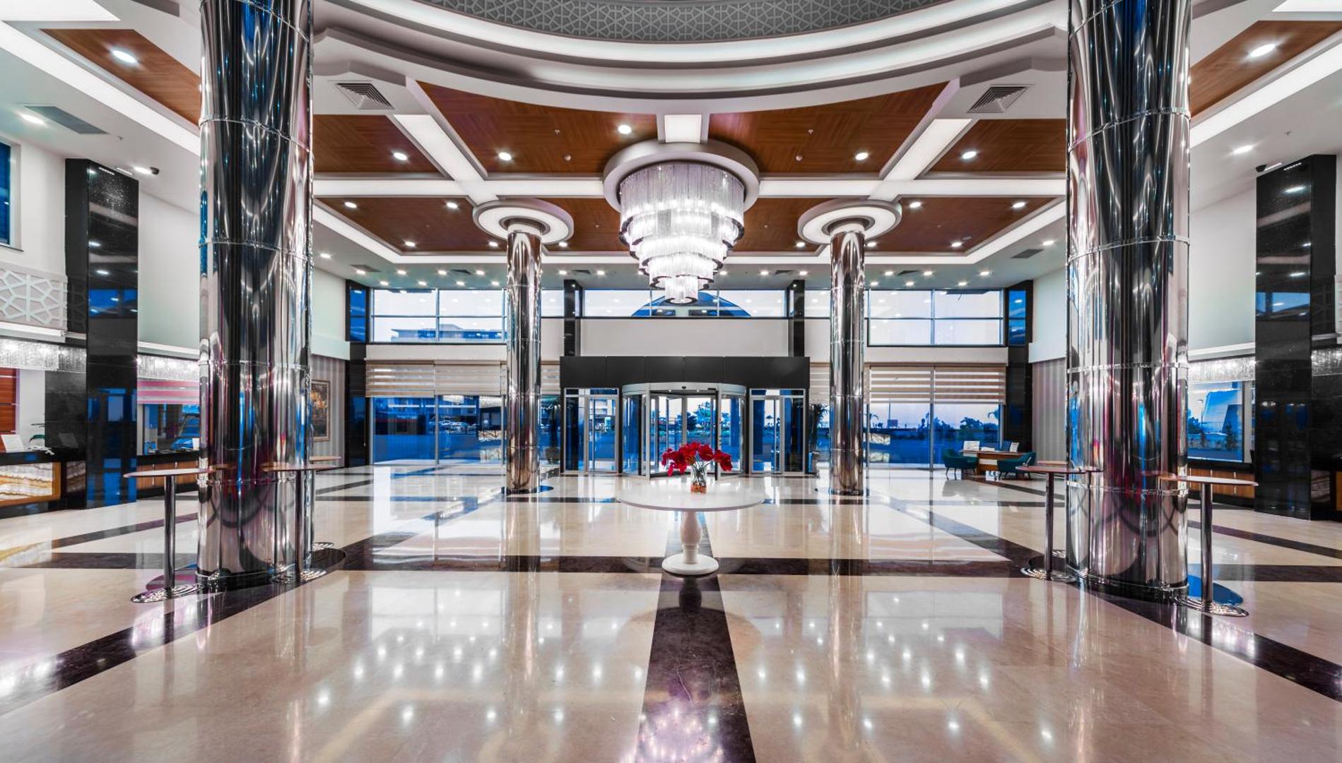 Lonicera Resort & Spa Hotel modernais lobby vestibils ar augstiem griestiem, greznu lustru, spīdīgām kolonnām un pulētu grīdu