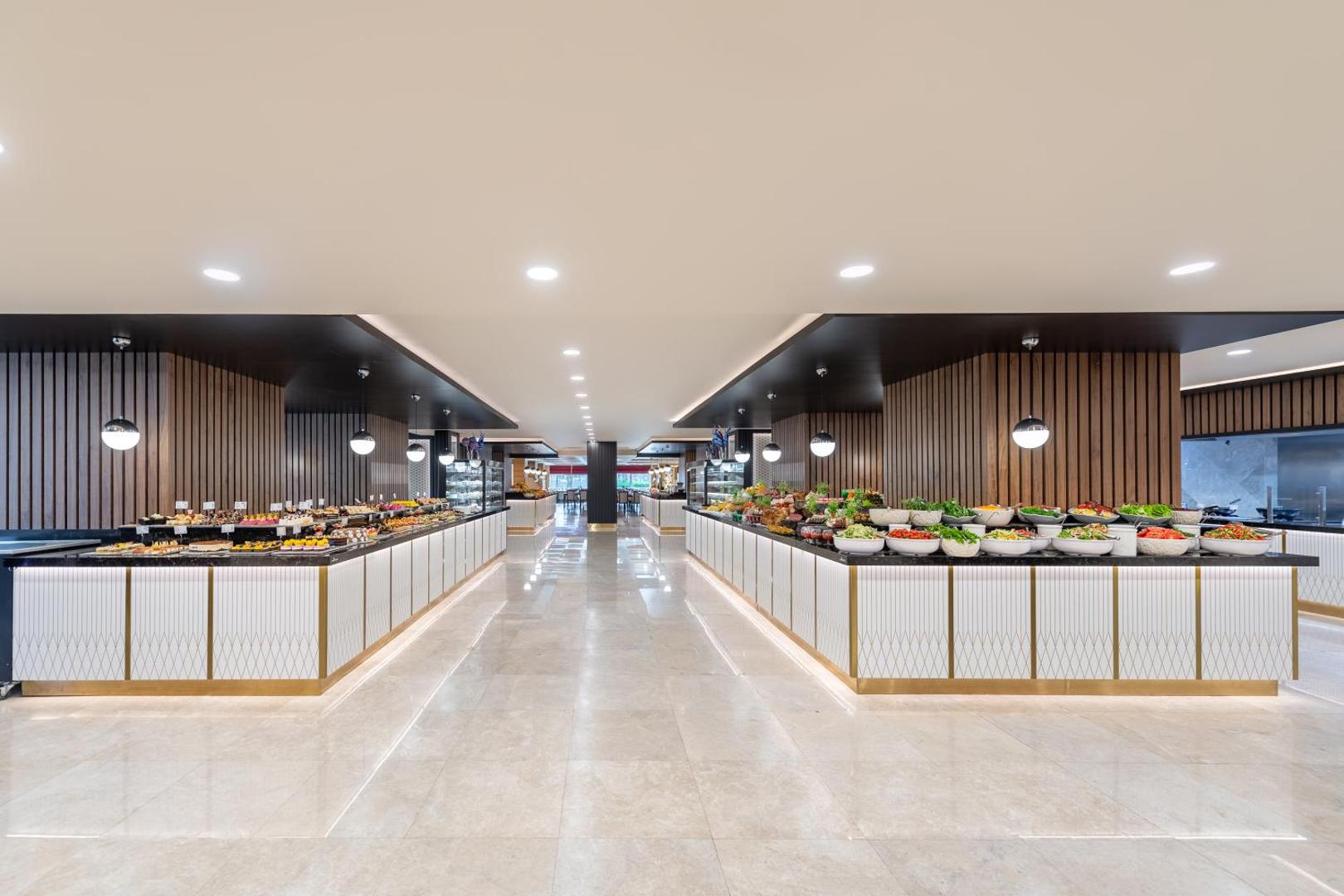 Sentido Kamelya Selin Luxury Resort & SPA bufetes tipa restorāns ar plašu uzkodu, salātu un desertu izvēli modernā interjerā.