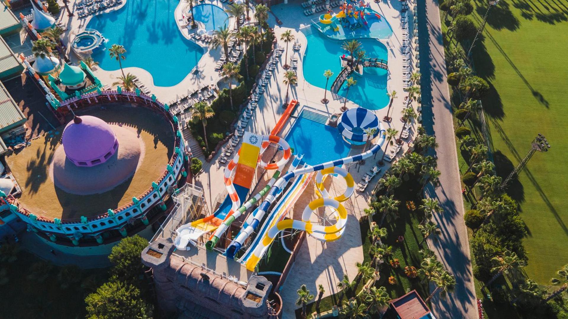 Sentido Kamelya Selin Luxury Resort & SPA akvaparks ar krāsainiem slidkalniņiem un vairākiem āra baseiniem no putna lidojuma Sidē.