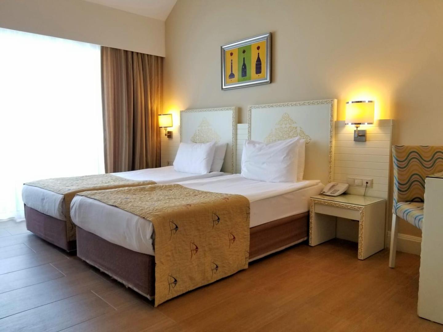Crystal Admiral Resort Suites & Spa numurs ar divām atsevišķām gultām, dekoratīviem galvgaļiem un gaišu interjeru