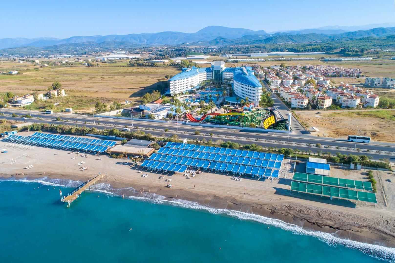 Crystal Admiral Resort Suites & Spa aerofoto — plaša teritorija ar akvaparku, baseiniem un privāto pludmali Vidusjūras krastā