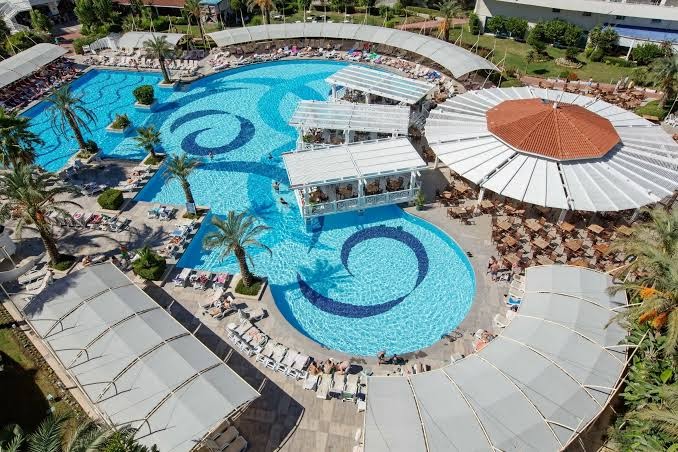 Crystal Admiral Resort Suites & Spa galvenais baseins no putna lidojuma Sidē, Turcijā — plaša atpūtas zona ar saulessargiem un bāru