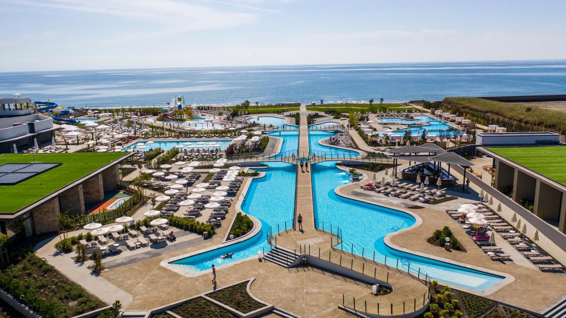The Wave Resort plašā teritorija ar vairākiem āra baseiniem, tiltiņiem un atpūtas zonām pie jūras Bulgārijā