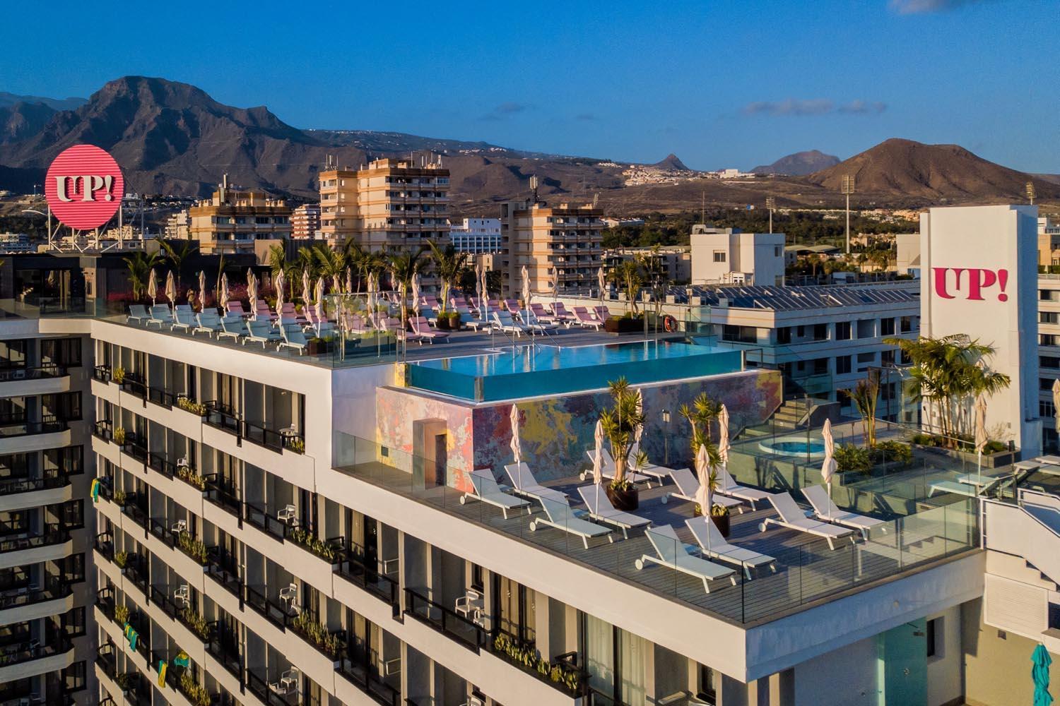 Hotel Bitacora modernā arhitektūra ar UP! terasi un baseinu uz kalnu fona Tenerifē saulrieta gaismā.