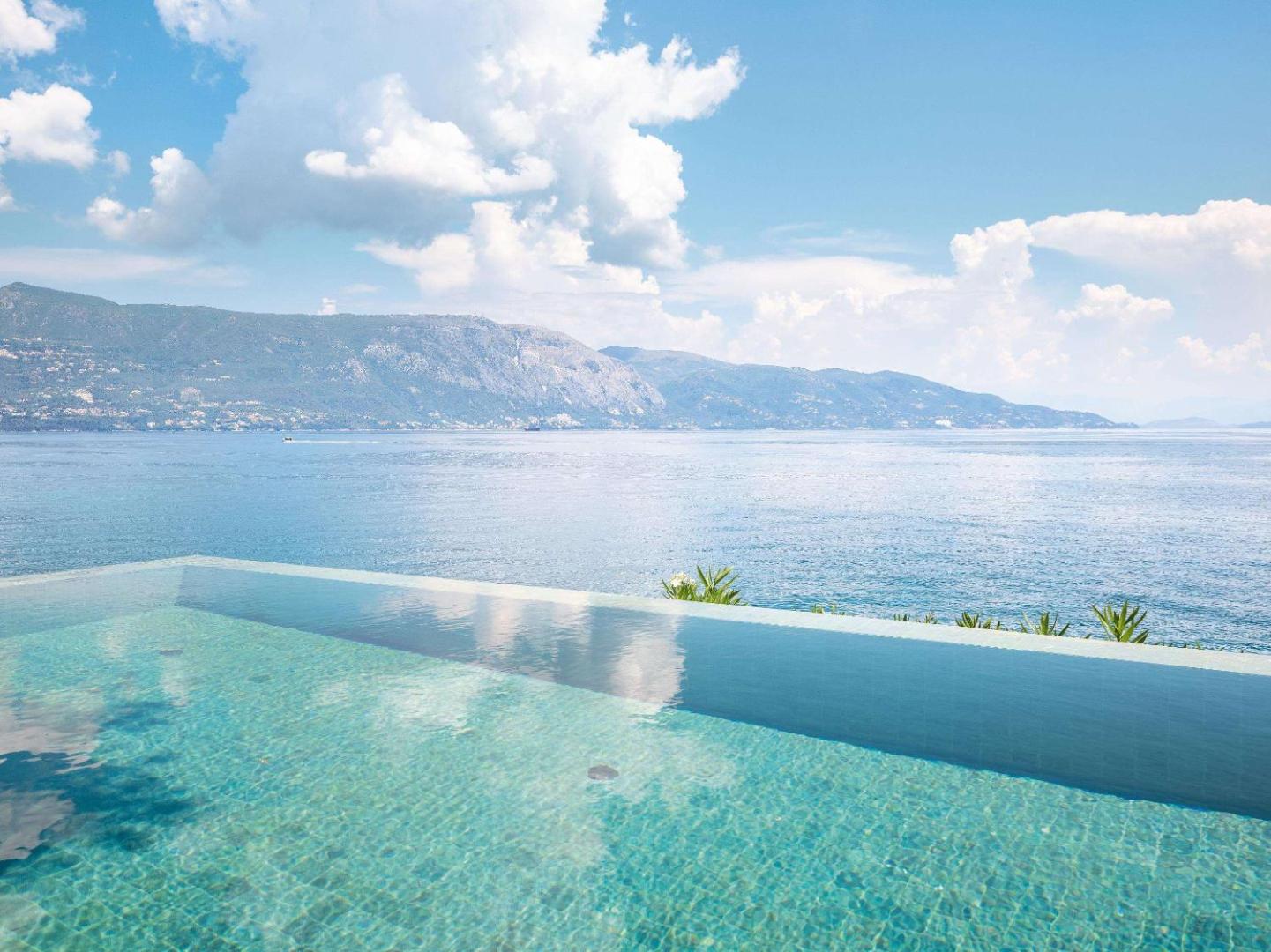 Corfu Imperial Grecotel Exclusive Resort bezmalas baseins ar skatu uz kalniem un jūru Korfu piekrastē