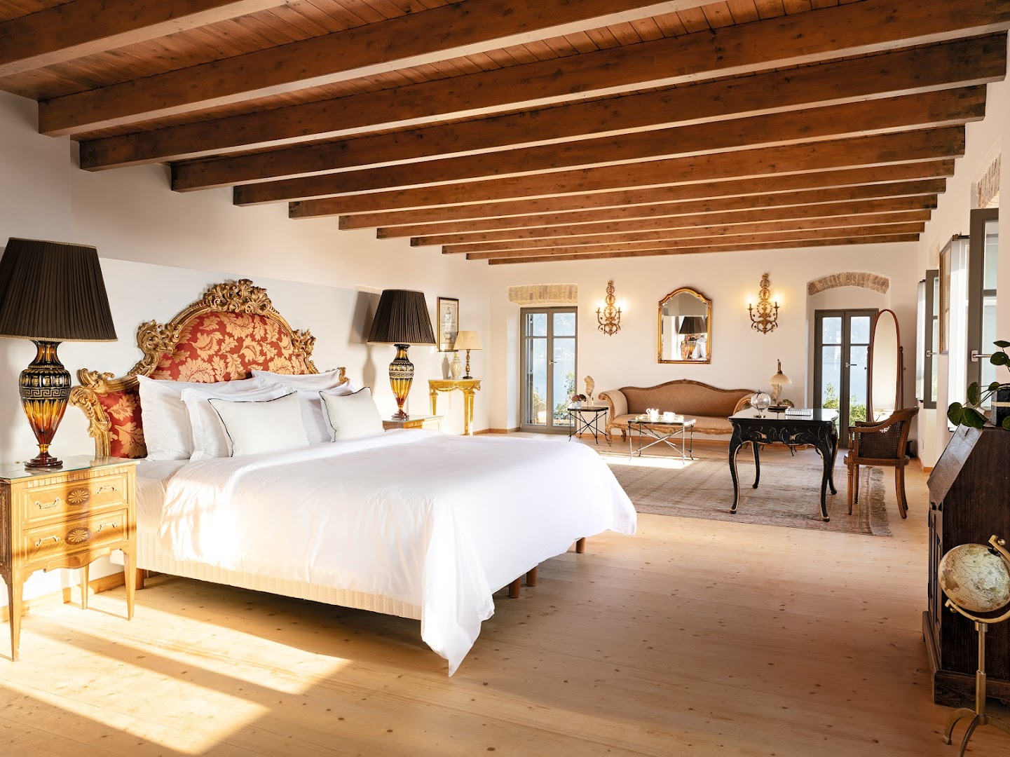 Corfu Imperial Grecotel Exclusive Resort grezns numurs ar koka siju griestiem, antīkām mēbelēm un lielu gultu ar dekoratīvu galvgalī