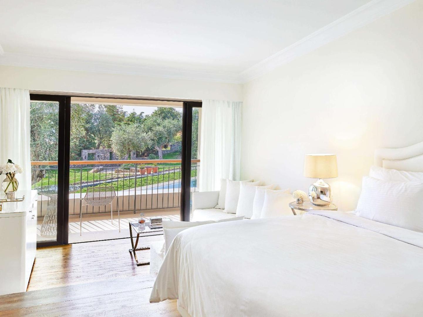 Corfu Imperial Grecotel Exclusive Resort gaišs guļamistabas numurs ar balkonu, skatu uz dārzu un mājīgu atpūtas stūrīti