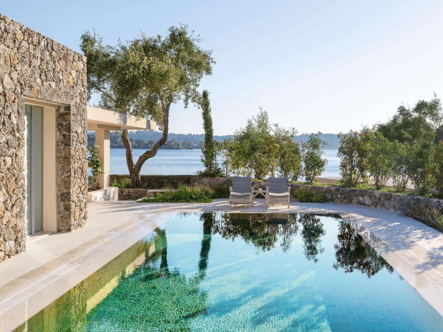 Privāts baseins pie akmens mūra villas Corfu Imperial Grecotel Exclusive Resort kūrortā ar skatu uz līci
