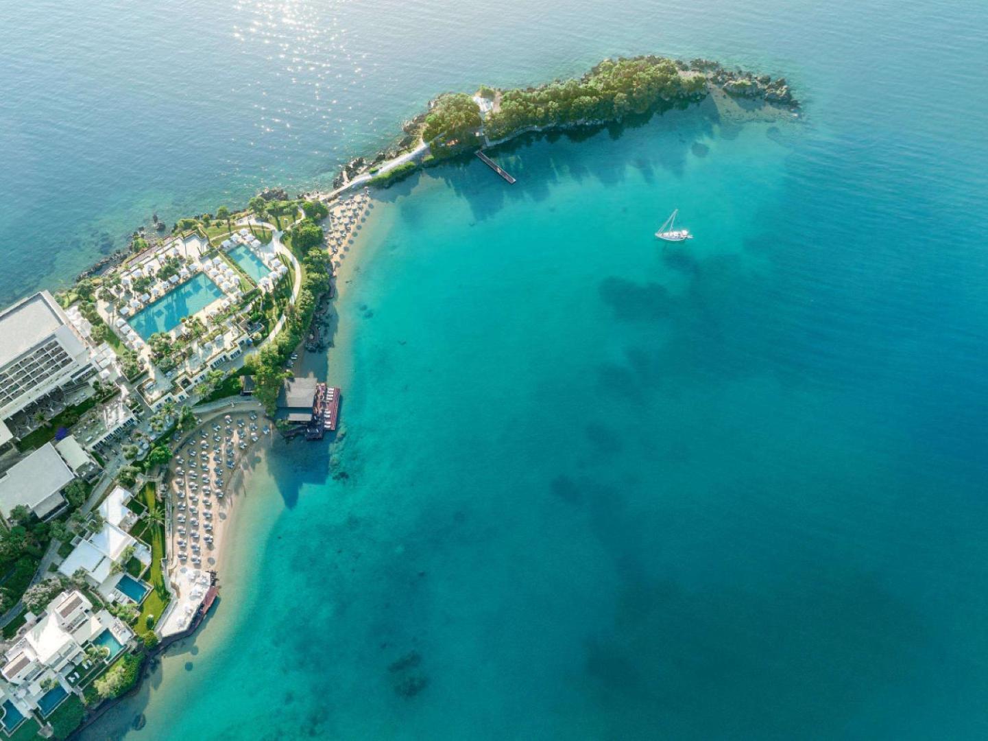 Corfu Imperial Grecotel Exclusive Resort skats no putna lidojuma uz pussalu, pludmalēm un tirkīzzilo Jonijas jūru Korfu salā, Grieķijā.