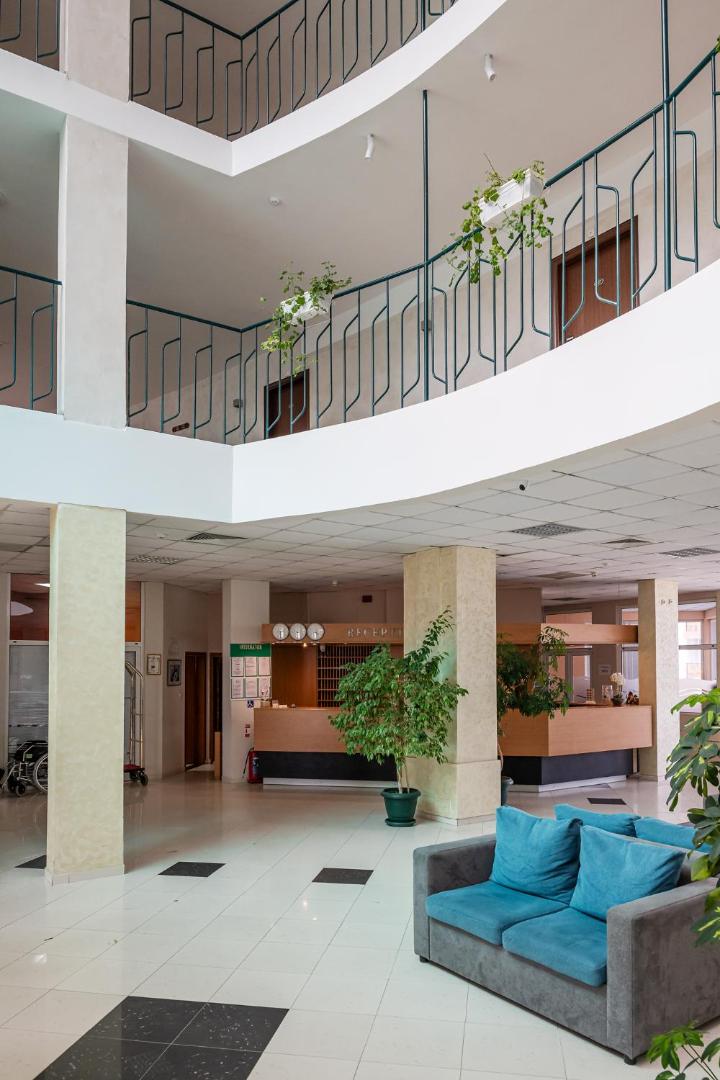 Flamingo Beach Hotel vestibils ar vairākiem stāviem, atpūtas zonu un ziliem dīvāniem — skats uz recepciju un gaiteņiem