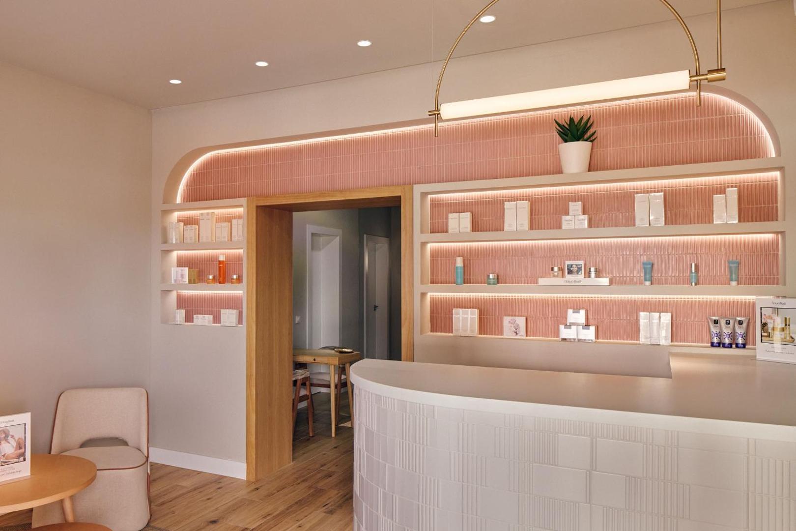 Viesnīcas Melia Jardines del Teide spa recepcijas zona ar rozā flīžu apdari un kosmētikas produktu plauktiem