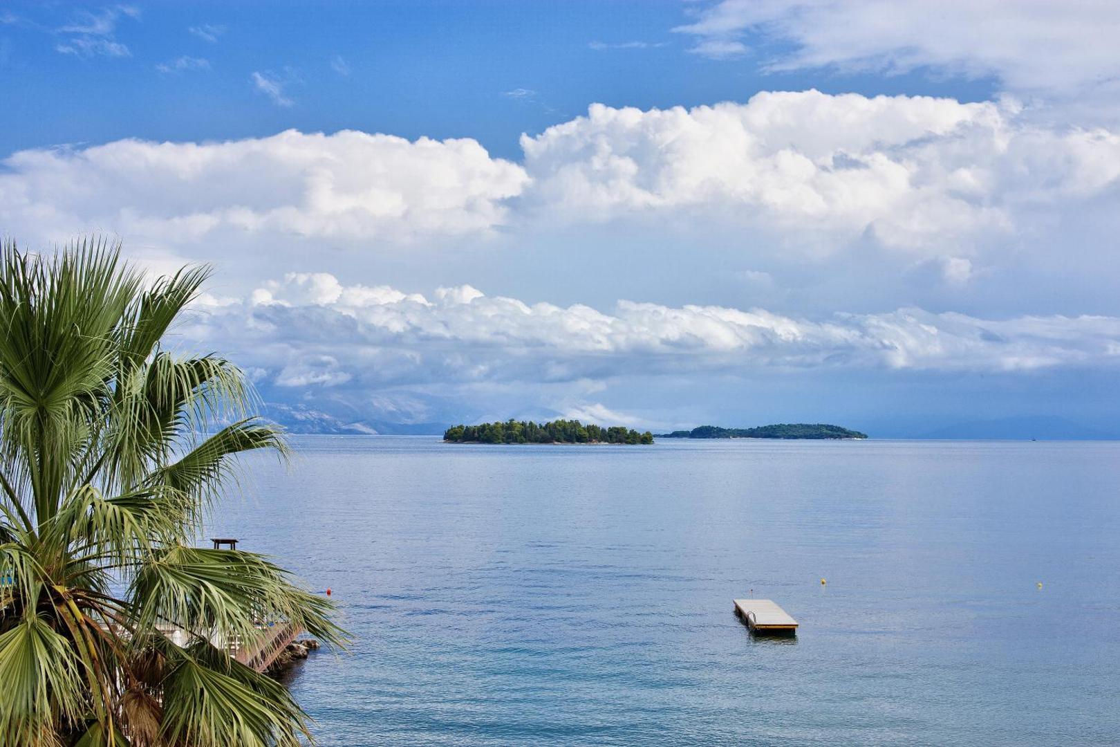 Kontokali Bay Resort & Spa skats uz Jonijas jūru un kaimiņu salām no viesnīcas piekrastes Korfu salā, Grieķijā