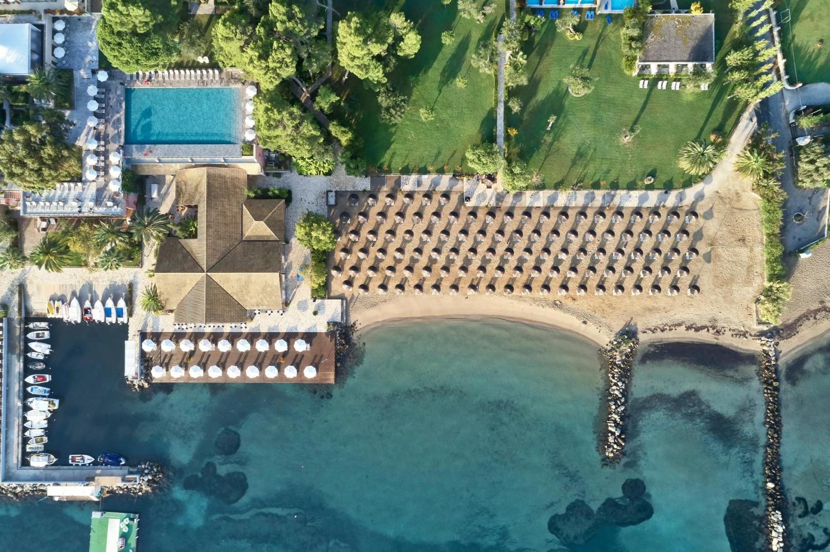 Kontokali Bay Resort & Spa skats no augšas uz pludmali, āra baseinu un jahtu piestātni Korfu salā, Grieķijā