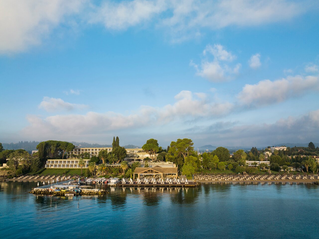 Kontokali Bay Resort & Spa galvenā ēka un restorāns pie jūras, skats no ūdens puses saulainā dienā