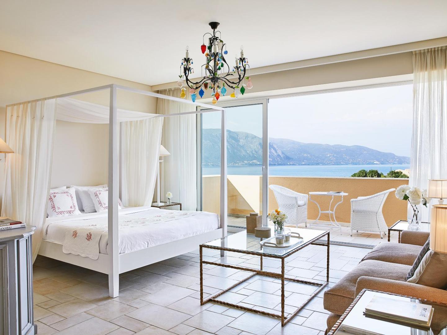 Grecotel Eva Palace plašs luksusa numurs ar atpūtas zonu, krāsainu lustru un lielu terasi ar skatu uz kalniem un jūru