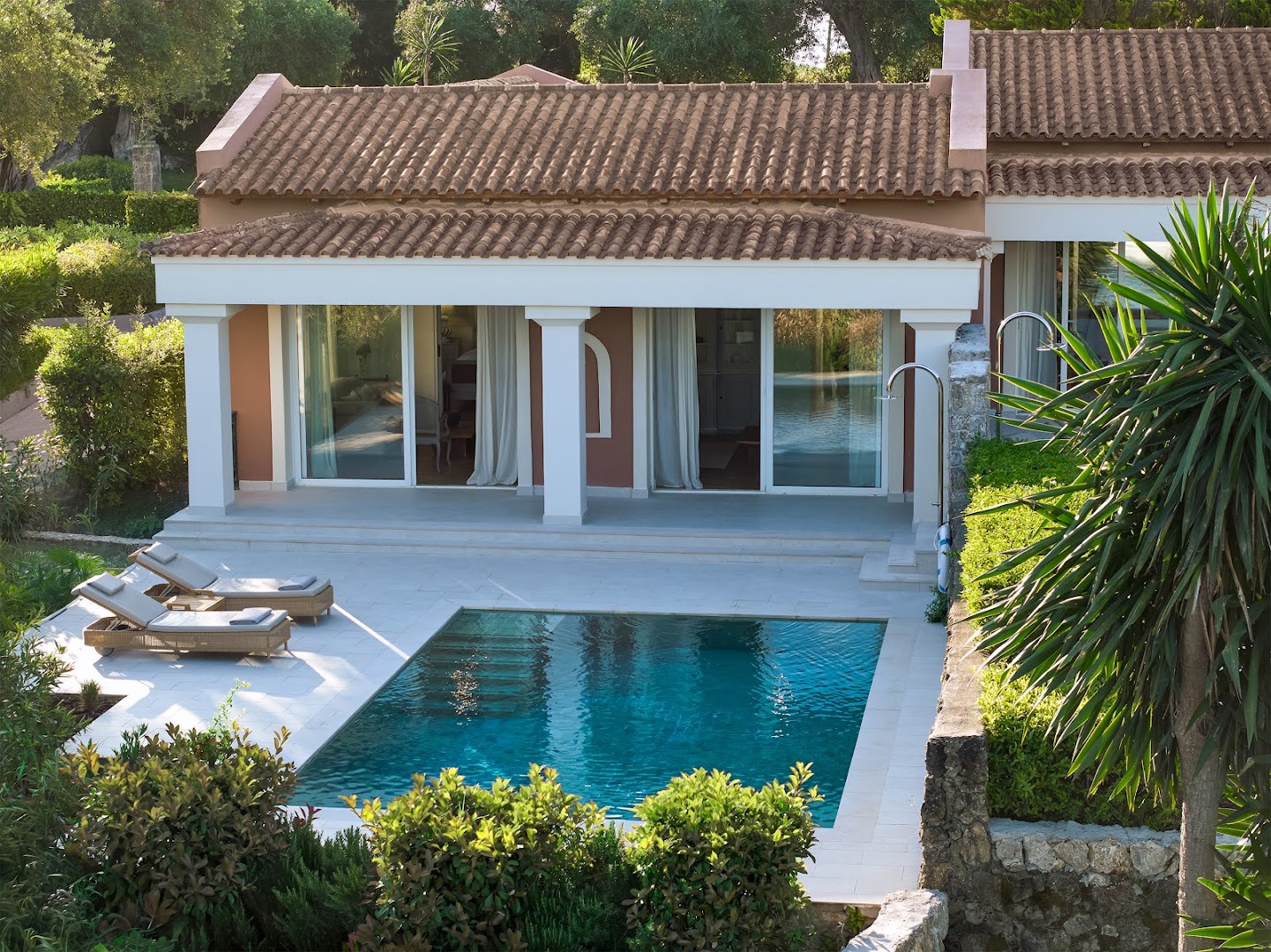 Grecotel Eva Palace bungalo ar privātu baseinu, terasi un sauļošanās krēsliem, ieskauts Vidusjūras dārzā.