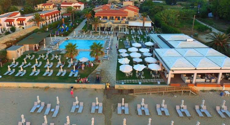 Acharavi Beach viesnīcas āra baseins un atpūtas zona ar saulessargiem, skats no augšas uz kūrorta centrālo daļu Korfu.