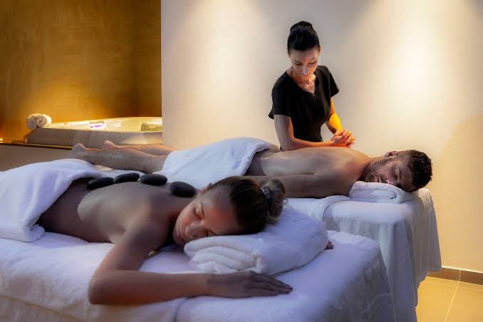Faros Hotel spa centrs piedāvā masāžu pāriem ar karstajiem akmeņiem — relaksējoša atmosfēra ar sveču gaismu un džakuzi