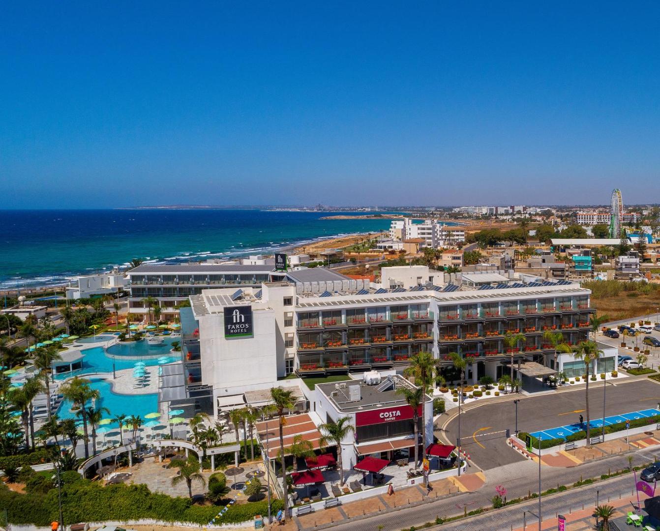 Faros Hotel Ayia Napa skats no putna lidojuma uz viesnīcas kompleksu, piekrasti un Vidusjūru saulainā dienā Kiprā
