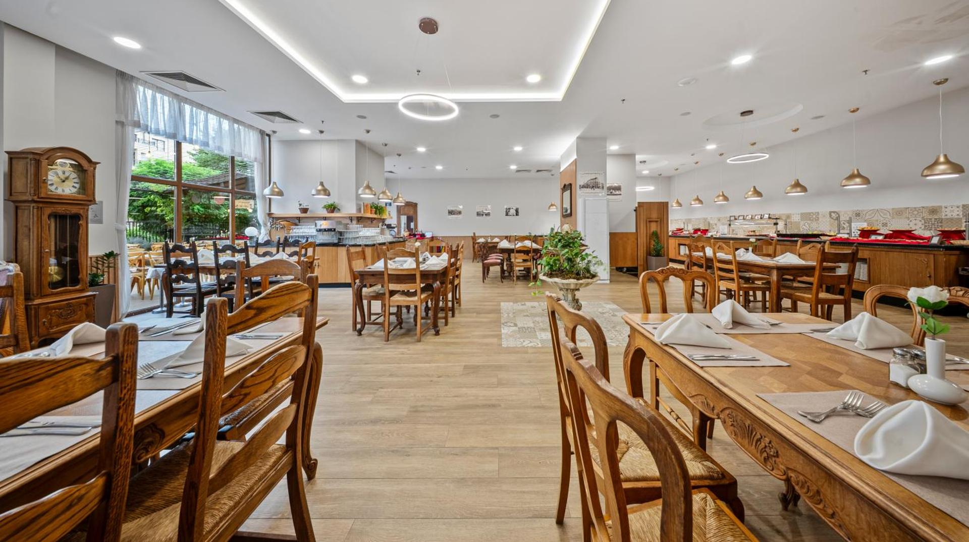 Melia Grand Hermitage restorāna iekštelpas ar koka mēbelēm, bufetes zonu un klasisku interjeru