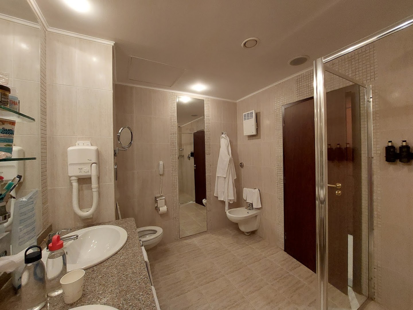 Viesnīcas Melia Grand Hermitage numura vannas istabas interjers ar fēnu, spoguli un higiēnas piederumiem